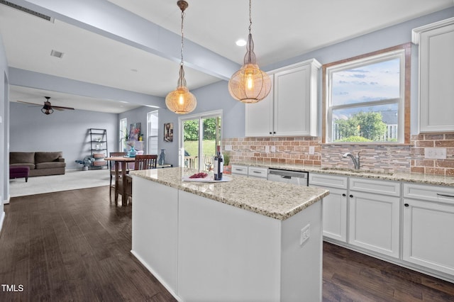 7 Faircroft Ct, Durham, NC 27703 - kitchen featuring a center island, dark wood finished floors, backsplash, white cabinets, and beamed ceiling