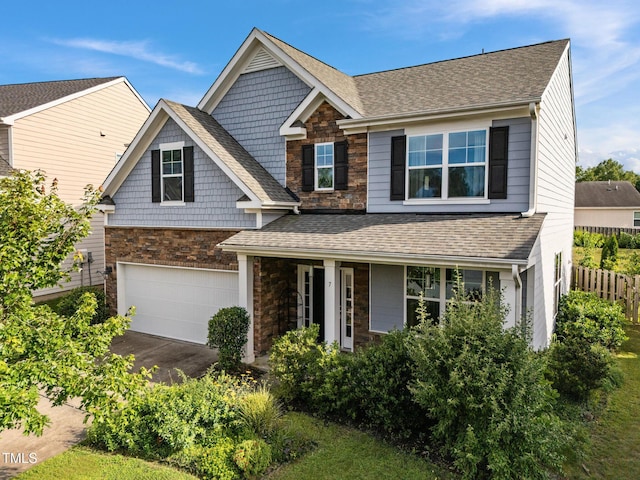 7 Faircroft Ct, Durham, NC 27703 - view of front of home with stone siding, an attached garage, driveway, and a shingled roof