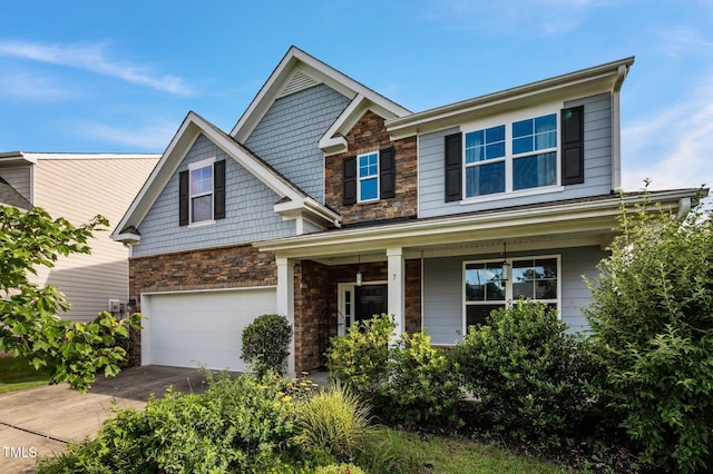 7 Faircroft Ct, Durham, NC 27703 - craftsman-style home featuring covered porch, a garage, stone siding, and concrete driveway