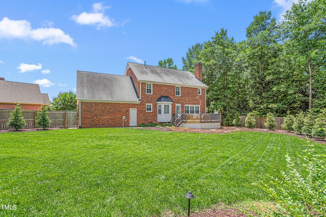 213 Brompton Ct, Burlington, NC 27215 - rear view of house with a fenced backyard, a deck, brick siding, a chimney, and a shingled roof