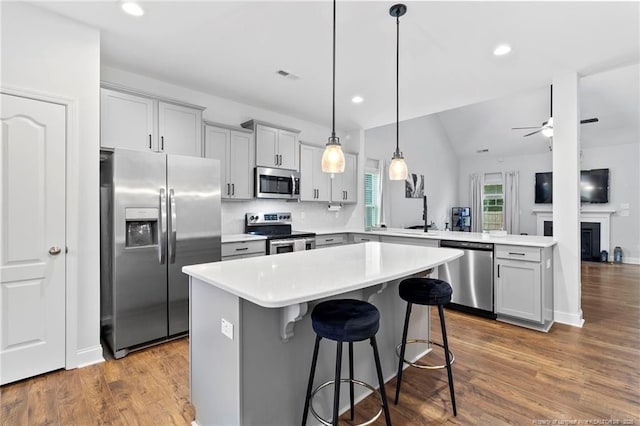6939 Running Fox Rd, Hope Mills, NC 28348 - kitchen featuring stainless steel appliances, light countertops, a peninsula, a breakfast bar, and recessed lighting