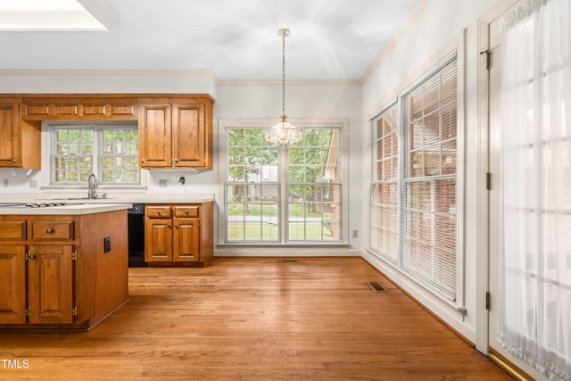 101 Turnberry Ln, Cary, NC 27511 - kitchen with a chandelier, brown cabinets, light countertops, light wood-type flooring, and ornamental molding
