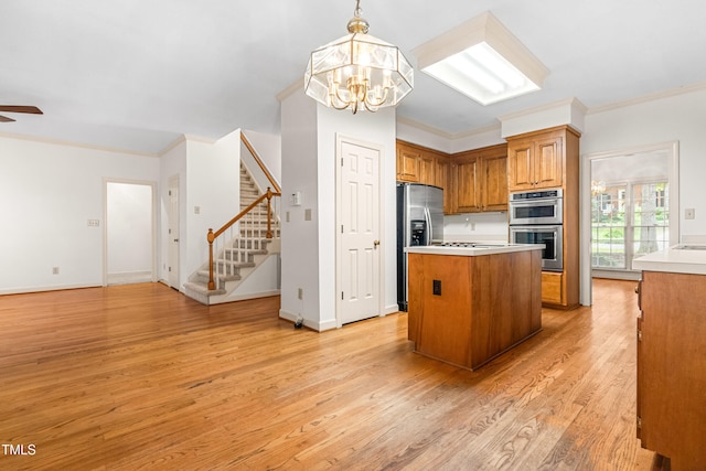 101 Turnberry Ln, Cary, NC 27511 - kitchen with stainless steel appliances, brown cabinets, a chandelier, light wood-type flooring, and a center island