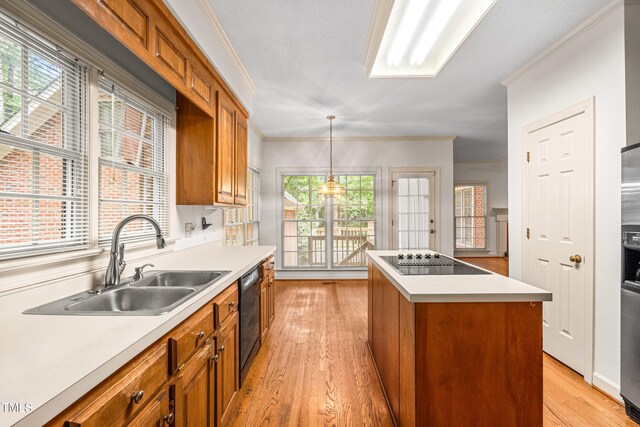 101 Turnberry Ln, Cary, NC 27511 - kitchen featuring black appliances, brown cabinets, crown molding, light wood finished floors, and a kitchen island