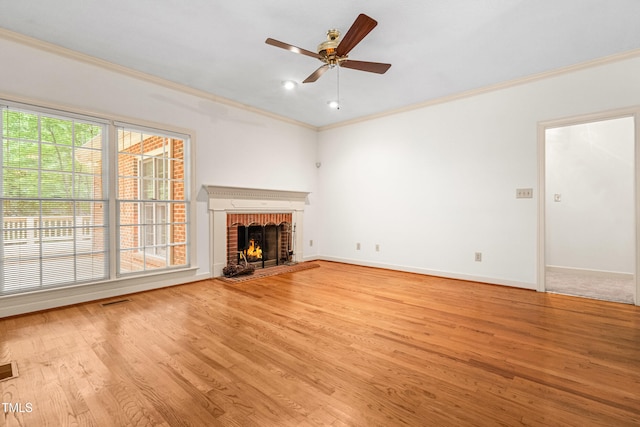 101 Turnberry Ln, Cary, NC 27511 - unfurnished living room featuring ornamental molding, light wood finished floors, a brick fireplace, and a ceiling fan
