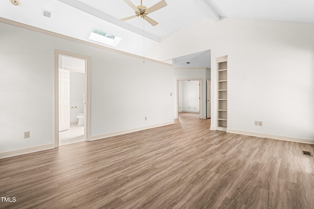 101 Turnberry Ln, Cary, NC 27511 - empty room featuring ceiling fan, high vaulted ceiling, a skylight, beamed ceiling, and wood finished floors