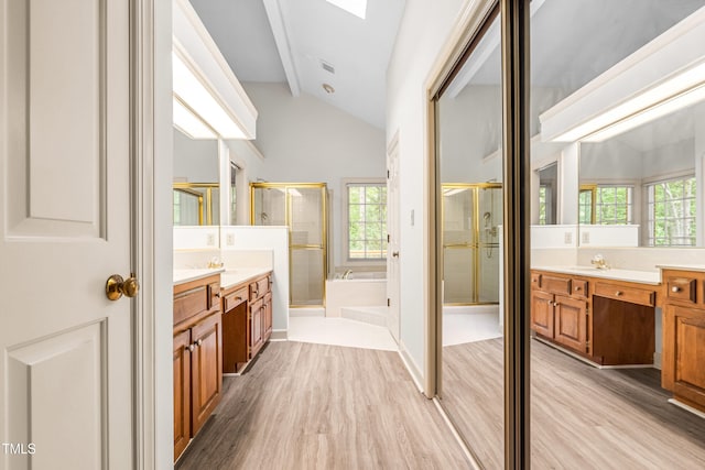 101 Turnberry Ln, Cary, NC 27511 - full bathroom featuring wood finished floors, a shower stall, two vanities, a garden tub, and a skylight