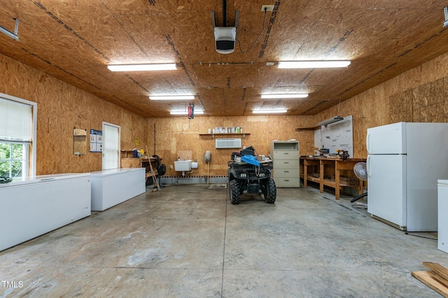 901 Tamaras Cir, Wake Forest, NC 27587 - garage with freestanding refrigerator, an AC wall unit, and a garage door opener