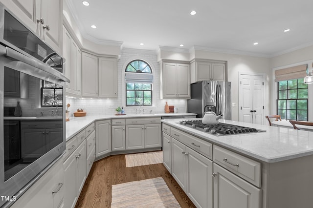 901 Tamaras Cir, Wake Forest, NC 27587 - kitchen with appliances with stainless steel finishes, a kitchen island, dark wood-type flooring, tasteful backsplash, and recessed lighting
