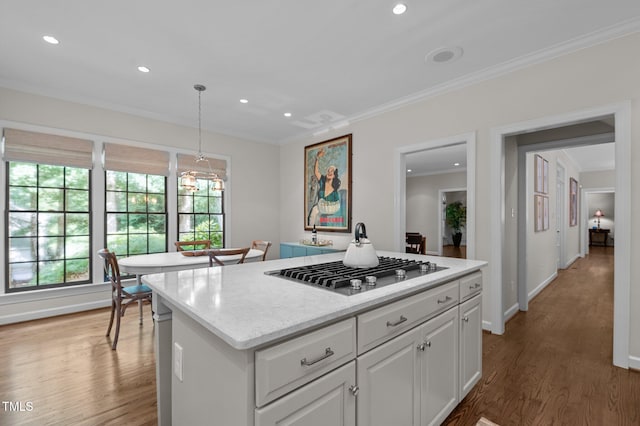 901 Tamaras Cir, Wake Forest, NC 27587 - kitchen featuring stainless steel gas cooktop, crown molding, light wood-style floors, a center island, and white cabinetry