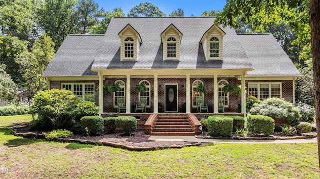 901 Tamaras Cir, Wake Forest, NC 27587 - cape cod home with brick siding, a porch, a front yard, and roof with shingles