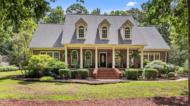 901 Tamaras Cir, Wake Forest, NC 27587 - cape cod-style house with covered porch, brick siding, a front yard, and a shingled roof