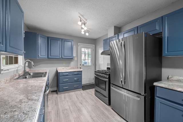 110 Starlite Dr, Carrboro, NC 27510 - kitchen featuring stainless steel appliances, blue cabinetry, under cabinet range hood, light countertops, and light wood-type flooring