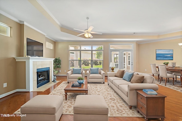 102 Mikaila Dr, Gibsonville, NC 27249 - living room featuring crown molding, ceiling fan, light wood-type flooring, and a tiled fireplace