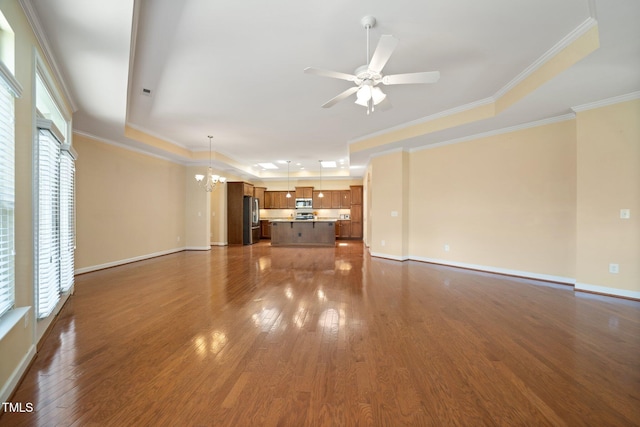 102 Mikaila Dr, Gibsonville, NC 27249 - unfurnished living room with a tray ceiling, a chandelier, ceiling fan, dark wood finished floors, and ornamental molding