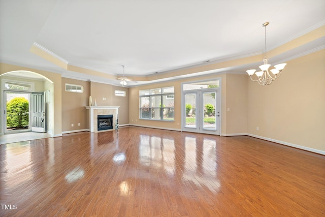 102 Mikaila Dr, Gibsonville, NC 27249 - unfurnished living room with a tray ceiling, ornamental molding, a ceiling fan, hardwood / wood-style floors, and arched walkways