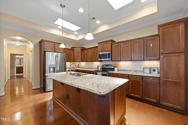 102 Mikaila Dr, Gibsonville, NC 27249 - kitchen with appliances with stainless steel finishes, a skylight, a tray ceiling, arched walkways, and ornamental molding