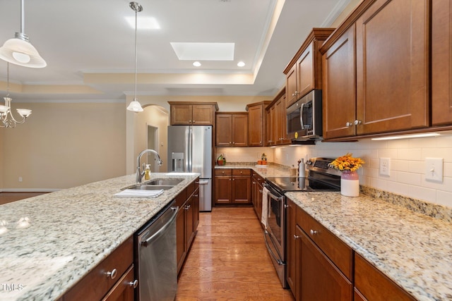 102 Mikaila Dr, Gibsonville, NC 27249 - kitchen with appliances with stainless steel finishes, a raised ceiling, light stone counters, a skylight, and backsplash