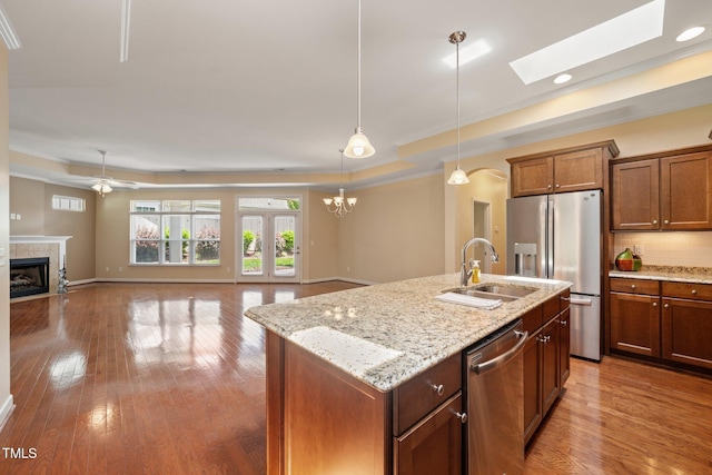 102 Mikaila Dr, Gibsonville, NC 27249 - kitchen with stainless steel appliances, a raised ceiling, a tiled fireplace, ornamental molding, and decorative light fixtures