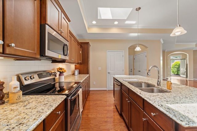 102 Mikaila Dr, Gibsonville, NC 27249 - kitchen with appliances with stainless steel finishes, arched walkways, a tray ceiling, tasteful backsplash, and a skylight
