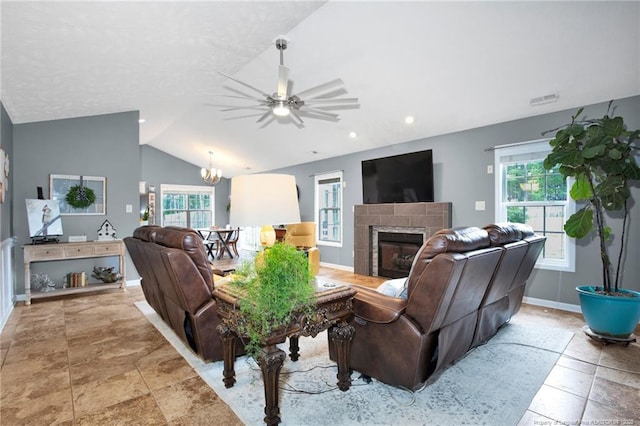 420 Gibson Dr, Raeford, NC 28376 - living room featuring a tiled fireplace, vaulted ceiling, healthy amount of natural light, a ceiling fan, and a chandelier