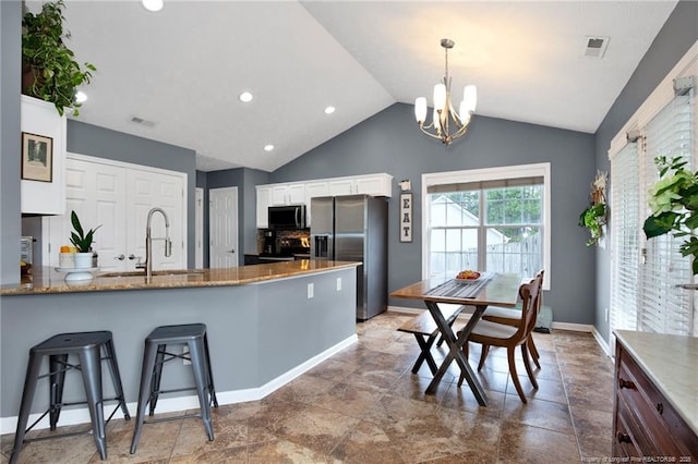 420 Gibson Dr, Raeford, NC 28376 - kitchen featuring stainless steel fridge with ice dispenser, white cabinetry, a chandelier, vaulted ceiling, and stone countertops