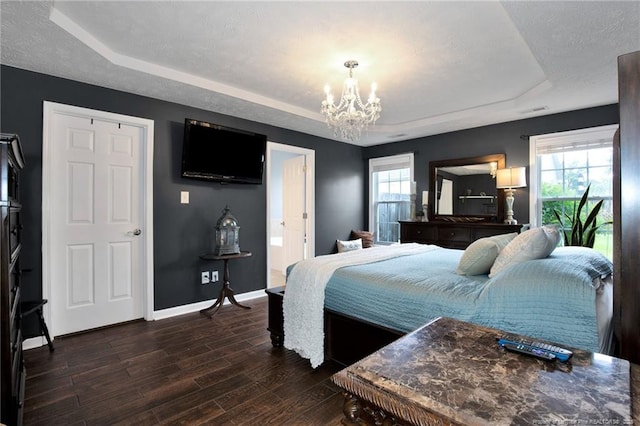 420 Gibson Dr, Raeford, NC 28376 - bedroom with a raised ceiling, a chandelier, multiple windows, and dark wood-style flooring
