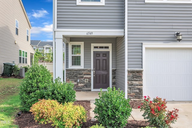 6549 Tremolo Trl, Raleigh, NC 27616 - doorway to property with stone siding and an attached garage