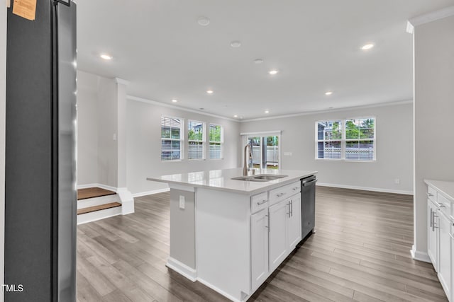 6549 Tremolo Trl, Raleigh, NC 27616 - kitchen with freestanding refrigerator, ornamental molding, stainless steel dishwasher, light wood-style flooring, and white cabinetry