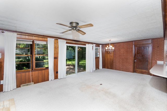 452 N Main St, Wendell, NC 27591 - unfurnished living room with plenty of natural light, a chandelier, carpet, a ceiling fan, and wood walls