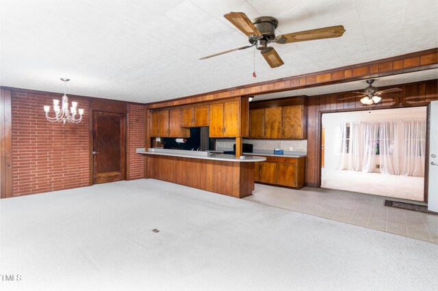 452 N Main St, Wendell, NC 27591 - kitchen featuring brown cabinets, a peninsula, light countertops, a chandelier, and ceiling fan