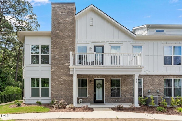 11548 Helmond Way # 104, Raleigh, NC 27617 - view of front of property featuring a balcony, brick siding, a porch, and a chimney