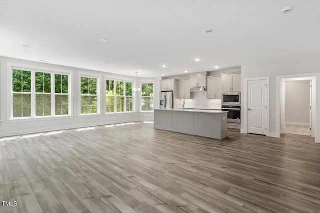11548 Helmond Way # 104, Raleigh, NC 27617 - unfurnished living room featuring plenty of natural light, wood finished floors, and recessed lighting