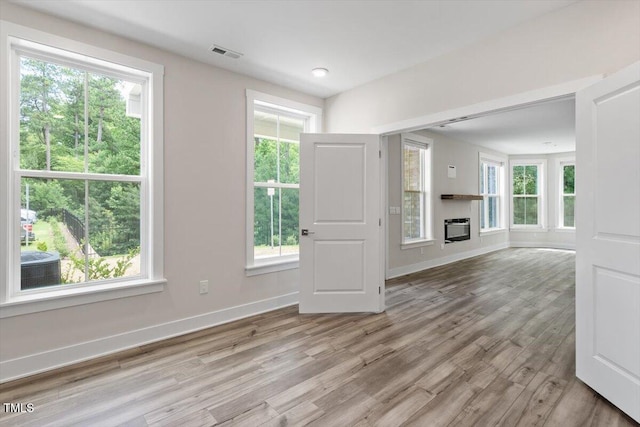 11548 Helmond Way # 104, Raleigh, NC 27617 - unfurnished living room featuring wood finished floors and a glass covered fireplace