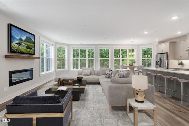 11548 Helmond Way # 104, Raleigh, NC 27617 - living room with plenty of natural light, light wood-type flooring, recessed lighting, and a glass covered fireplace