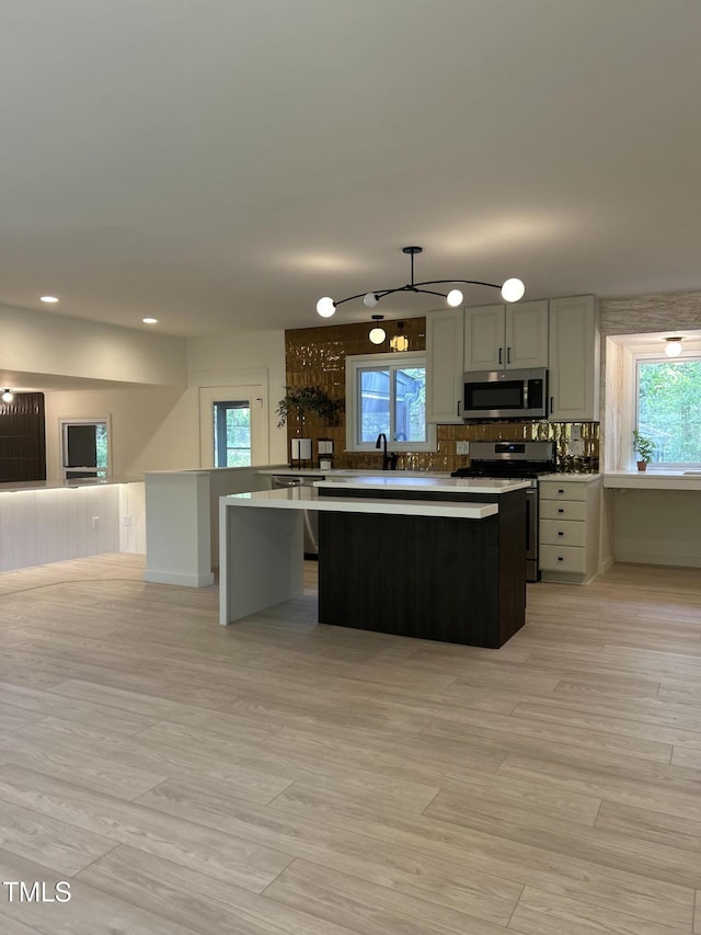 4812 Latimer Rd, Raleigh, NC 27609 - kitchen with appliances with stainless steel finishes, a center island, healthy amount of natural light, recessed lighting, and tasteful backsplash