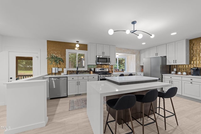 4812 Latimer Rd, Raleigh, NC 27609 - kitchen featuring stainless steel appliances, a chandelier, tasteful backsplash, a breakfast bar area, and a peninsula