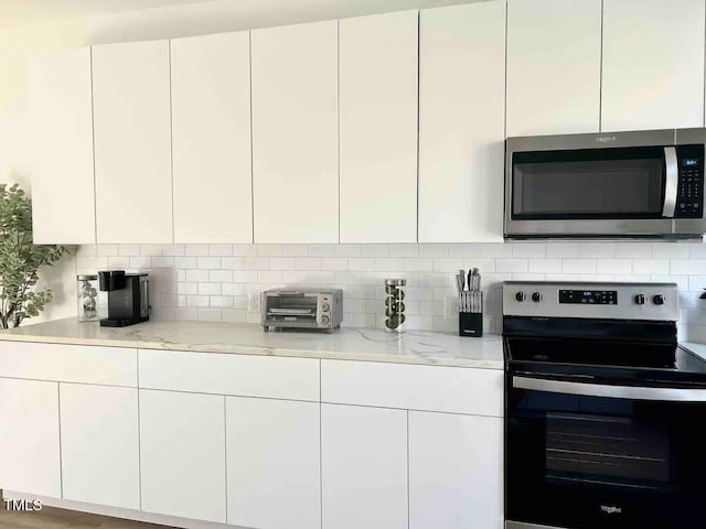 1106 Nova St, Durham, NC 27713 - kitchen with stainless steel microwave, electric range, white cabinets, tasteful backsplash, and modern cabinets