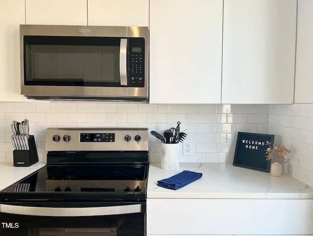1106 Nova St, Durham, NC 27713 - kitchen with stainless steel appliances, white cabinets, backsplash, and light stone countertops