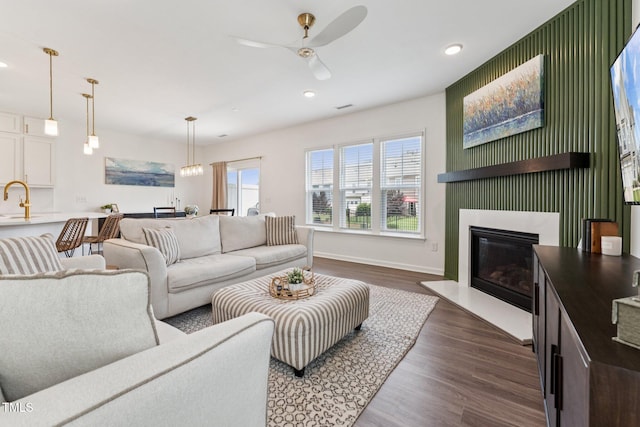 3194 Retama Run, New Hill, NC 27562 - living room featuring dark wood-style flooring, recessed lighting, ceiling fan, and a glass covered fireplace