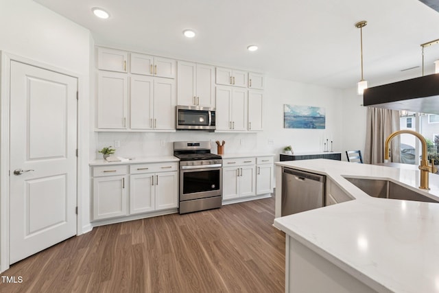 3194 Retama Run, New Hill, NC 27562 - kitchen featuring stainless steel appliances, light wood-type flooring, white cabinets, hanging light fixtures, and recessed lighting