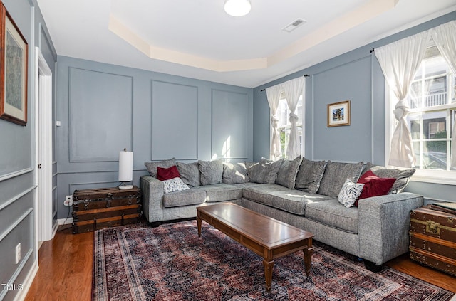 513 Dragby Ln, Raleigh, NC 27603 - living room with a decorative wall, a raised ceiling, and wood finished floors