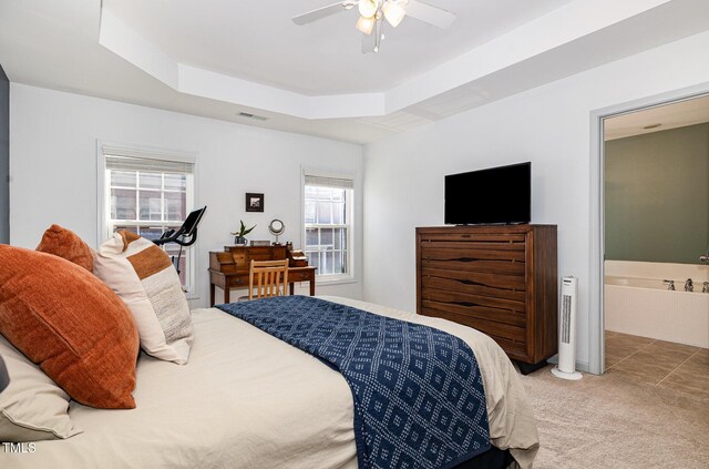 513 Dragby Ln, Raleigh, NC 27603 - bedroom with light colored carpet, a tray ceiling, ceiling fan, and ensuite bath