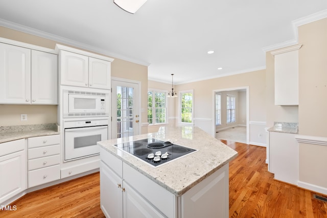 306 Neuse Ridge Dr, Clayton, NC 27527 - kitchen with white appliances, light wood-style floors, crown molding, a center island, and white cabinetry