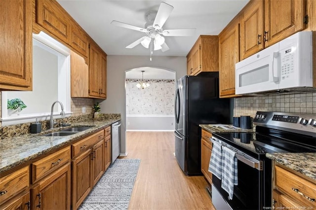 325 Hamilton St, Fayetteville, NC 28301 - kitchen with range with electric stovetop, white microwave, light wood-style floors, and brown cabinets