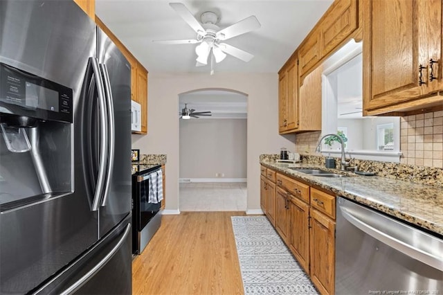 325 Hamilton St, Fayetteville, NC 28301 - kitchen with stainless steel appliances, ceiling fan, arched walkways, decorative backsplash, and brown cabinets
