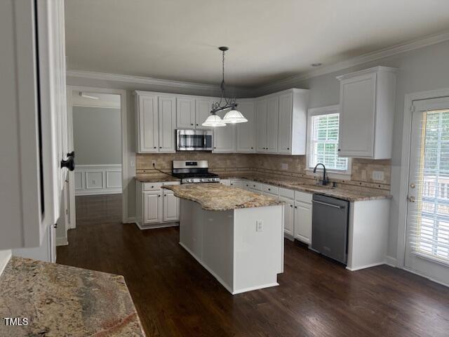 114 Council Gap Ct, Cary, NC 27513 - kitchen with stainless steel appliances, white cabinets, dark wood-style flooring, and ornamental molding