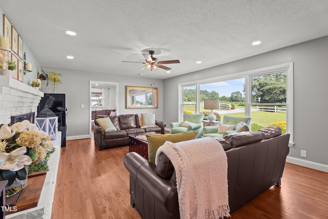 12082 NC-42, Fuquay Varina, NC 27526 - living room featuring a ceiling fan, wood finished floors, a textured ceiling, a fireplace, and recessed lighting
