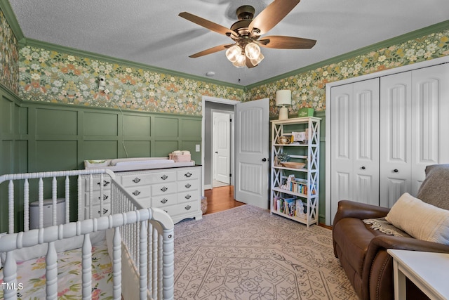 12082 NC-42, Fuquay Varina, NC 27526 - bedroom featuring wallpapered walls, a decorative wall, ornamental molding, a closet, and wainscoting