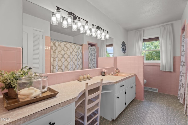 12082 NC-42, Fuquay Varina, NC 27526 - bathroom with tile walls, double vanity, wainscoting, and tile patterned flooring